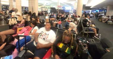Large group of travelers waiting at LAX airport for a Honolulu flight.