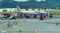 A Volotea airplane on a tarmac surrounded by emergency vehicles.
