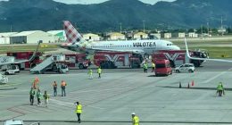 A Volotea airplane on a tarmac surrounded by emergency vehicles.