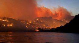 Homes in Crete burning in a wildfire at night.