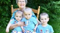 Grandmother with three grandsons sitting on a rocking chair.