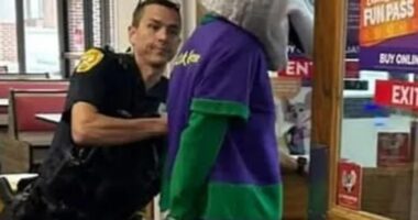 Police officer arresting Chuck E. Cheese mascot at a Florida Chuck E. Cheese restaurant.