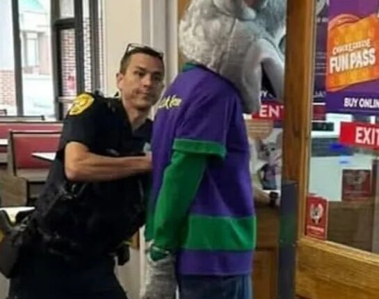 Police officer arresting Chuck E. Cheese mascot at a Florida Chuck E. Cheese restaurant.