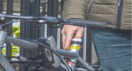 A man placing a USB drive into a bicycle's seat post.
