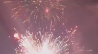 Fireworks exploding over water.