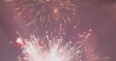 Fireworks exploding over water.