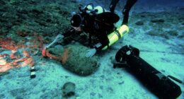 Diver exploring an underwater shipwreck site.