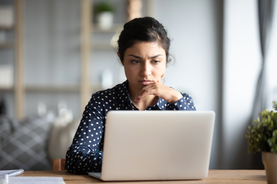 Woman looking concerned at her laptop.