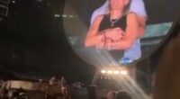 Large screen showing a couple embracing at a Coldplay concert.
