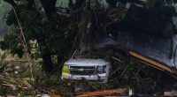 SUV buried in debris after a flood.