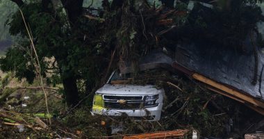 SUV buried in debris after a flood.