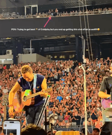 Chris Martin of Coldplay playing guitar on stage.