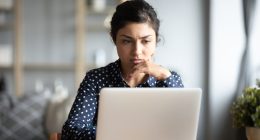 Woman looking concerned at her laptop.