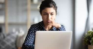 Woman looking concerned at her laptop.