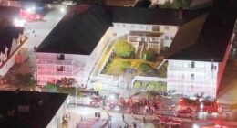 Aerial view of firefighters responding to an incident at a motel at night.