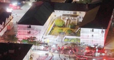 Aerial view of firefighters responding to an incident at a motel at night.
