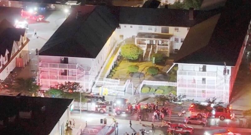 Aerial view of firefighters responding to an incident at a motel at night.
