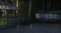 Nighttime photo of an archery range with targets and people.