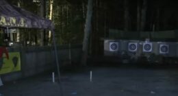 Nighttime photo of an archery range with targets and people.