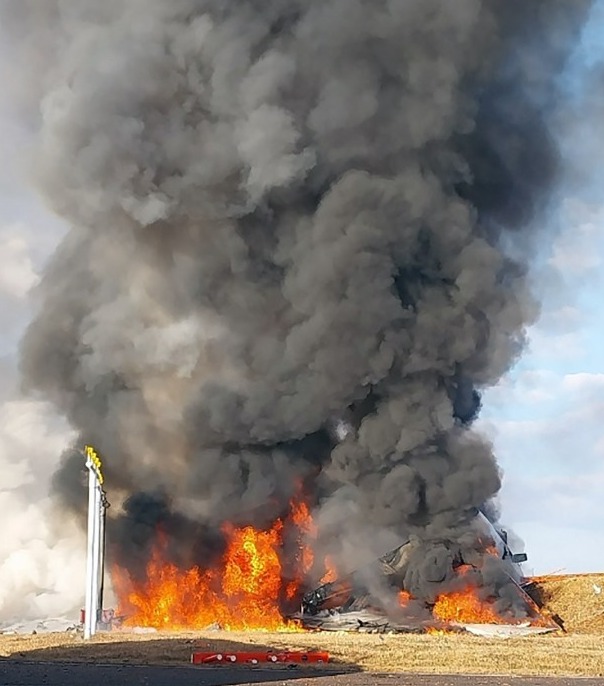 Large fire and smoke billowing from a burning vehicle.