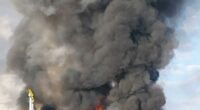 Large fire and smoke billowing from a burning vehicle.