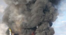Large fire and smoke billowing from a burning vehicle.