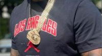Man wearing a black Los Angeles shirt and gold jewelry.
