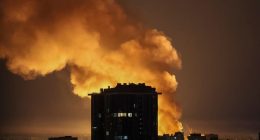 Explosion near a city building at night.