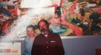 Photo of a man and a boy in front of a mural.