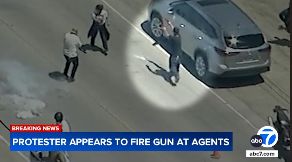 Video still of a protestor appearing to fire a gun at agents.