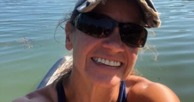 Selfie of Sunshine Stewart paddleboarding on a Maine pond.
