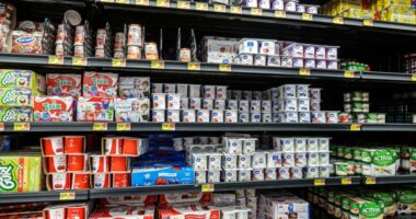 Walmart dairy aisle with various yogurts on shelves.