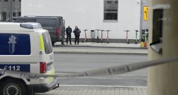 Police officers at a cordoned-off area.