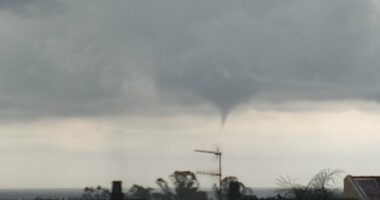 Waterspout over rooftops.