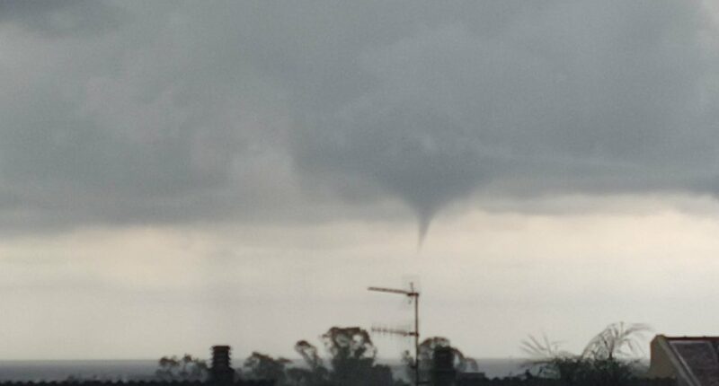 Waterspout over rooftops.