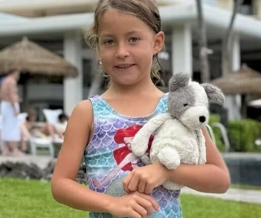 Girl holding a stuffed dog.
