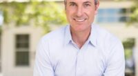 Portrait of a smiling man in a light blue shirt.