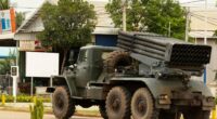 Cambodian military truck with rocket launcher driving away.