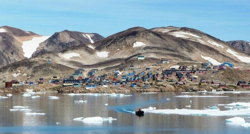 Kap Hope, Ittoqqortoormiit, Greenland, with colorful houses and ice floes in the water.