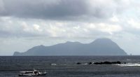 Akuseki Island, Japan, viewed from the sea with a boat.