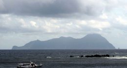 Akuseki Island, Japan, viewed from the sea with a boat.
