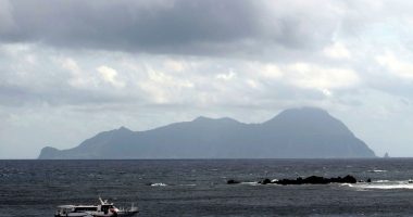 Akuseki Island, Japan, viewed from the sea with a boat.