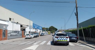 Street scene of parked cars near a police vehicle.