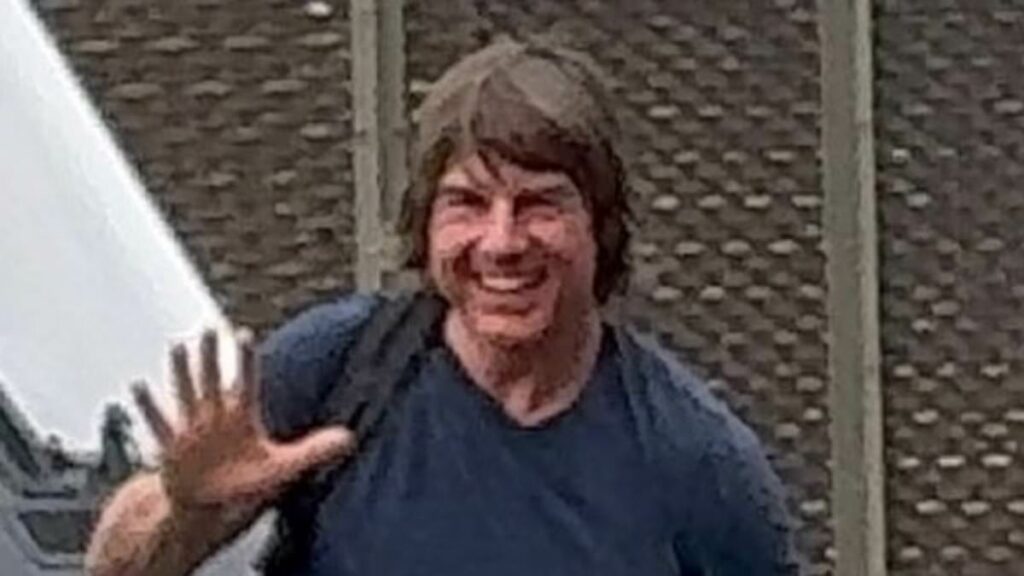 Tom Cruise grins and waves as he lands in London with Ana de Armas