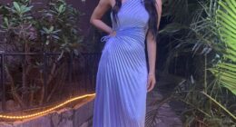 Woman in a light blue pleated dress.