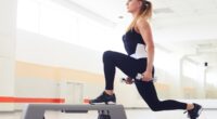 Young woman holding dumbbells while being in squat position in a health club. Fitness, sport, training, gym and lifestyle concept