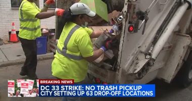Screenshot of sanitation workers loading trash into a garbage truck during a strike.