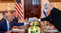 Benjamin Netanyahu handing a document to Donald Trump at a meeting.