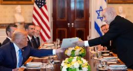 Benjamin Netanyahu handing a document to Donald Trump at a meeting.