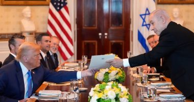 Benjamin Netanyahu handing a document to Donald Trump at a meeting.